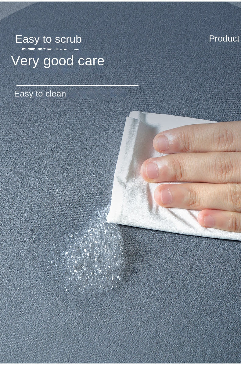 A hand is shown rubbing a white cleaning cloth on a gray floor, leaving a residue of white powder.