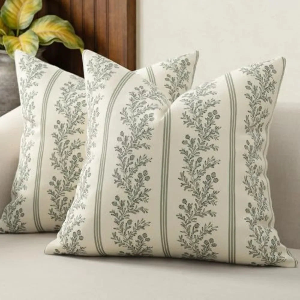 A close-up of a vintage striped floral throw pillow cover with gray and white botanical patterns.