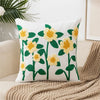 White throw pillow cover embroidered with yellow and green floral designs