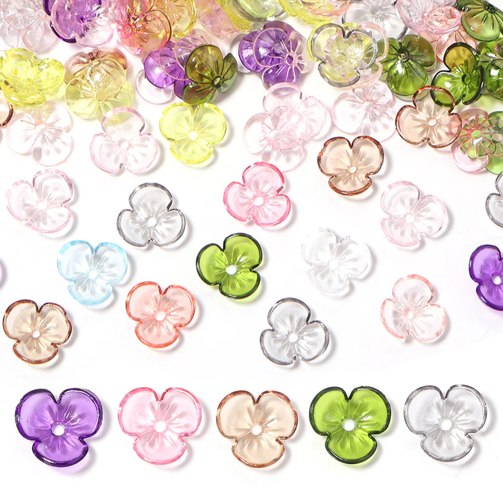 Assortment of colorful resin flower bead caps for jewelry making in various shades of pink, purple, green, and clear.