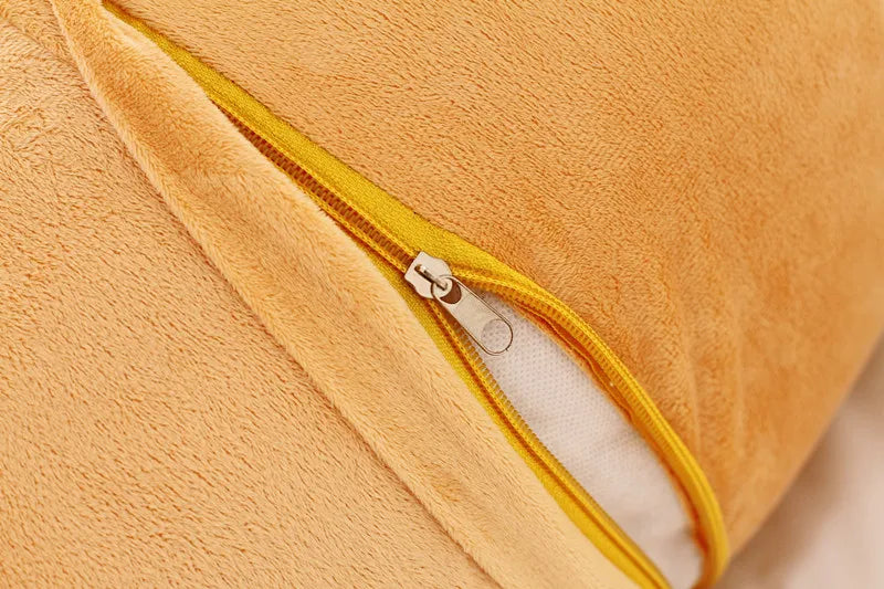 Close-up of an orange Rilakkuma plush bed pillow or sofa cushion with a yellow zipper detail.