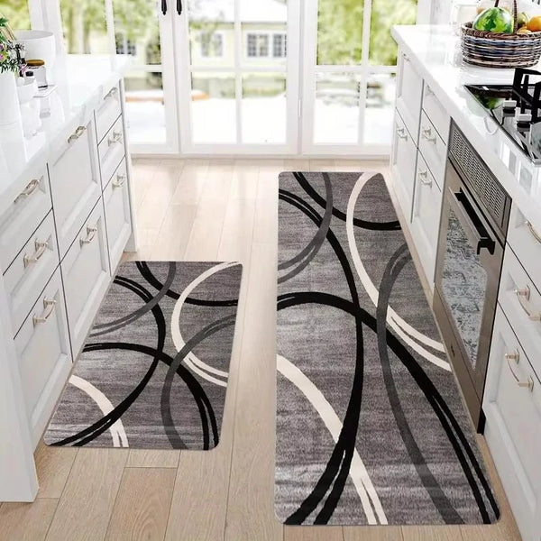 A gray and white geometric rug with black lines placed on a light wood floor.
