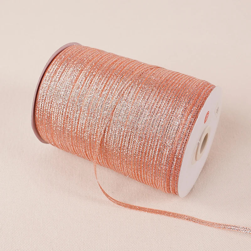 A roll of 10-meter gold and silver glitter satin ribbon is shown on a light background.