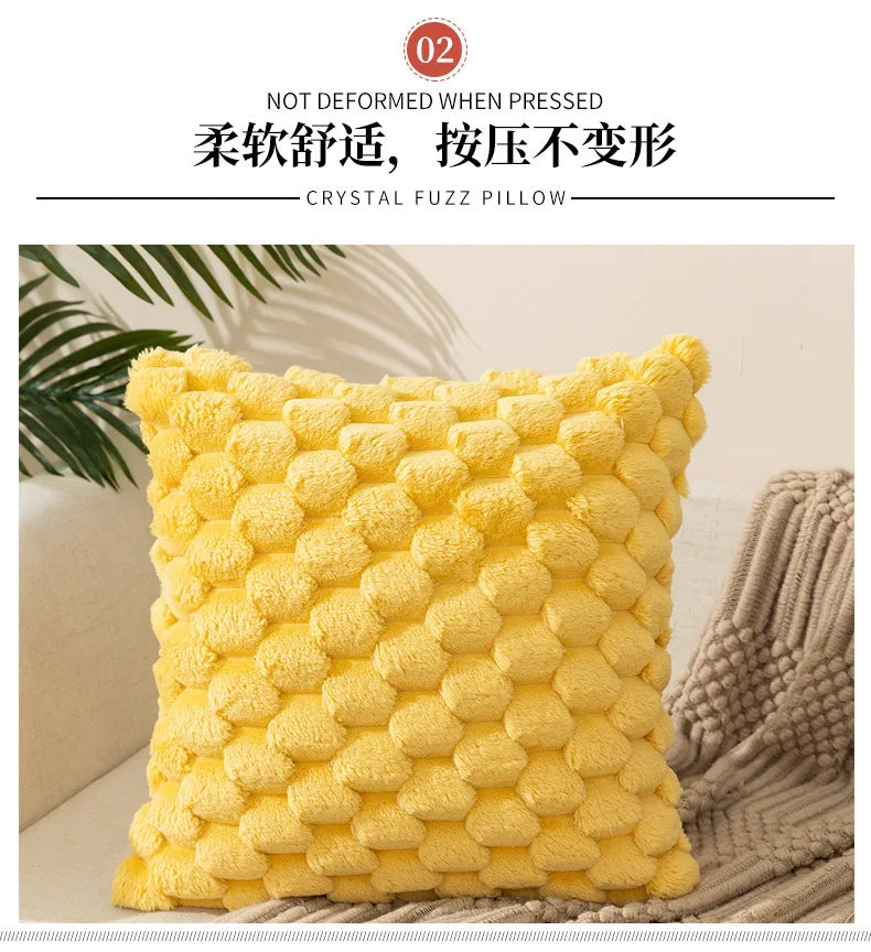 A bright yellow crystal fuzz pillow resting on a neutral textured fabric.