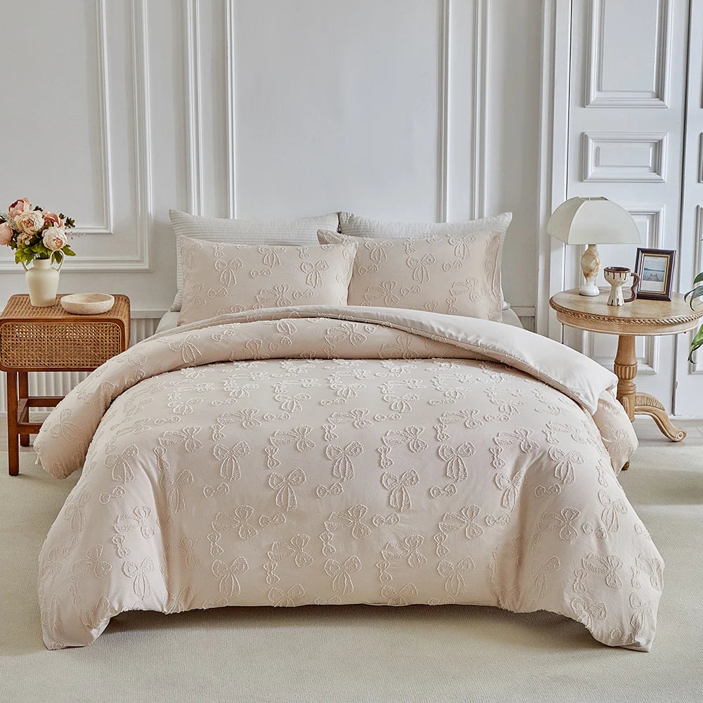 A beige luxury quilt duvet set displayed on a bed with white molding and light neutral decor.