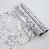 Rolls of silver glitter sequins used as a table runner for weddings and parties