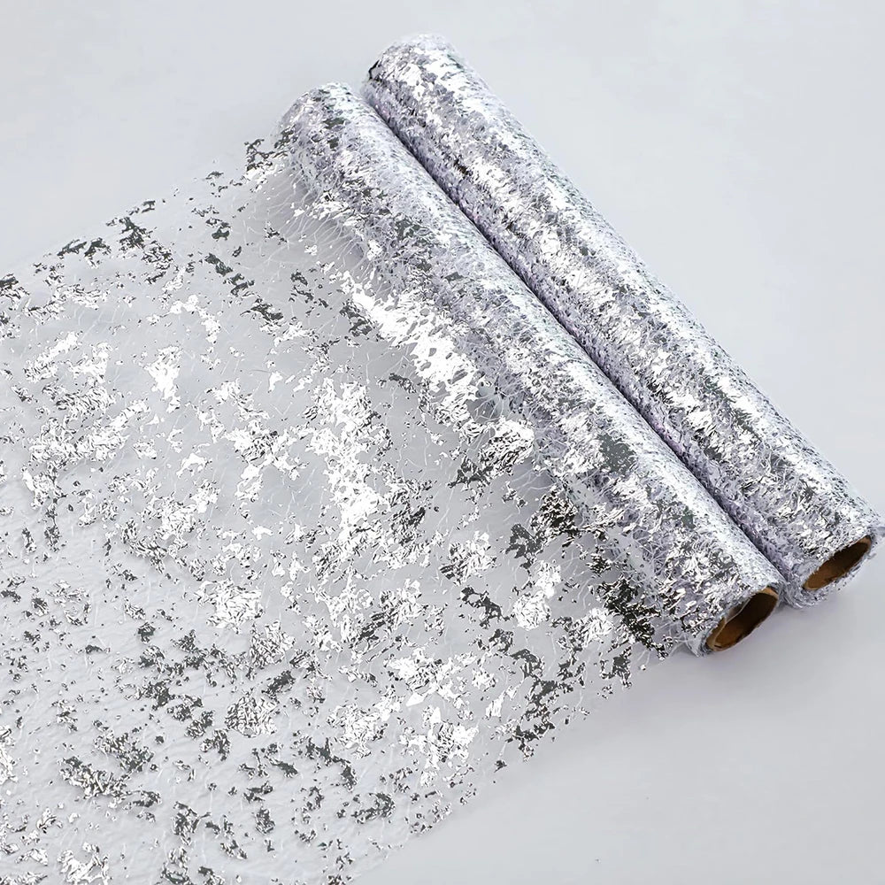 Rolls of silver glitter sequins used as a table runner for weddings and parties