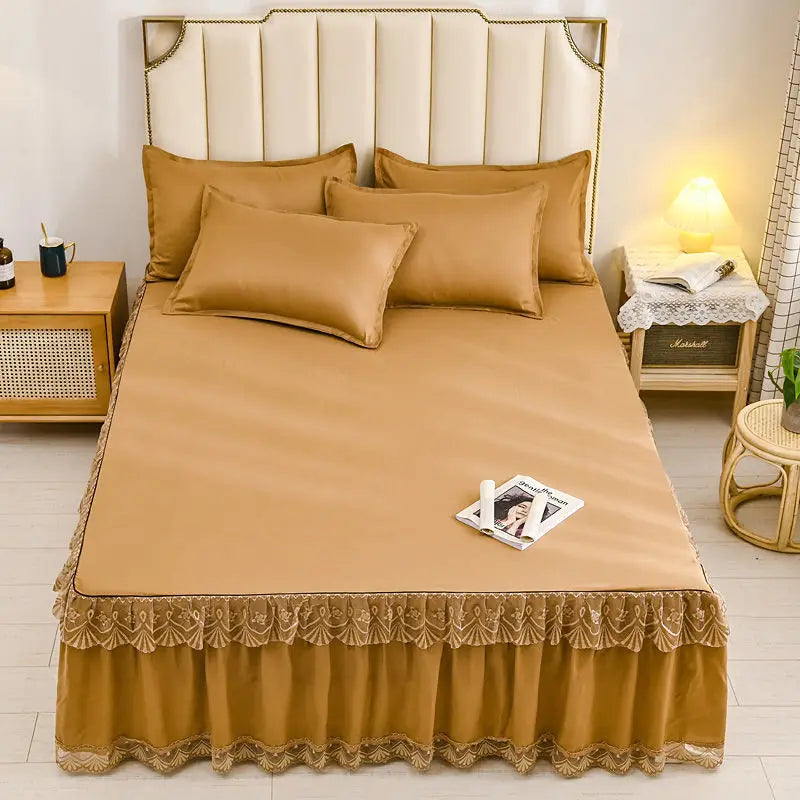 A luxurious tan floral bed skirt protecting a mattress, featuring a padded headboard and bedding.