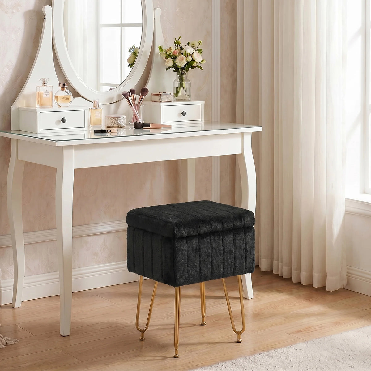 A dark gray faux fur ottoman with gold metal legs displayed on a white vanity table.