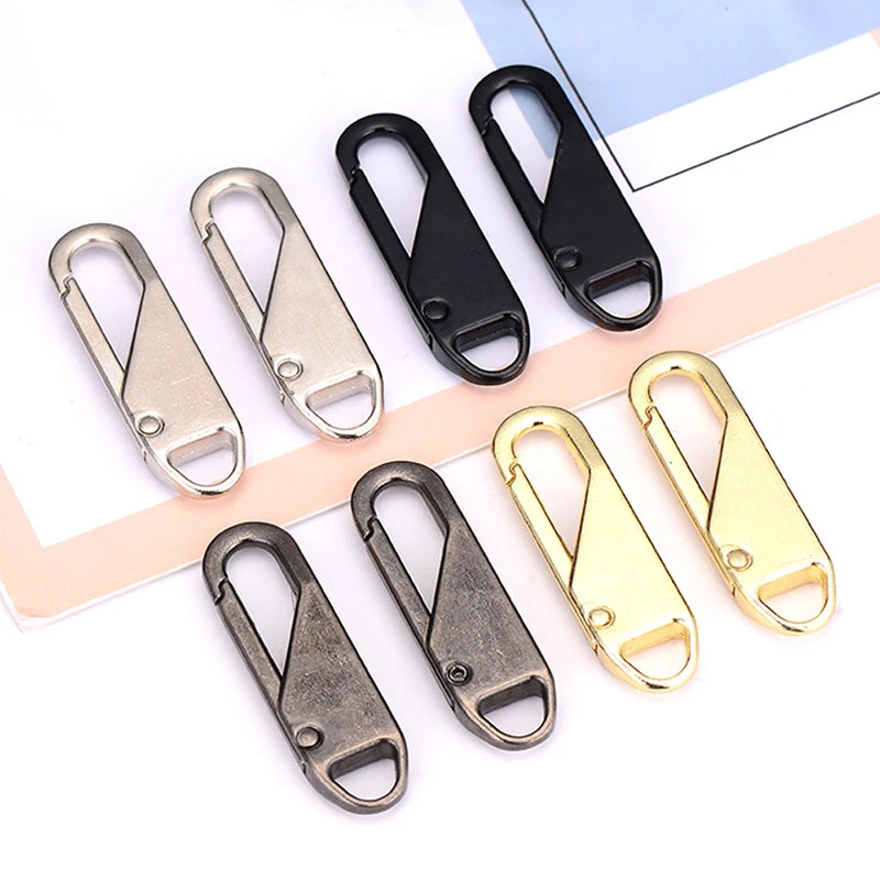 A collection of metal zipper sliders in various finishes including silver, black, and gold.