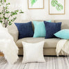 A collection of navy, teal, and white corduroy striped throw pillows displayed on a light sofa.