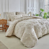 A beige tufted floral duvet cover set with matching pillowcases displayed on a bed in a bright room.