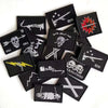 A collection of black embroidered pirate flags featuring skulls, swords, and hooks, with hook and loop backing.