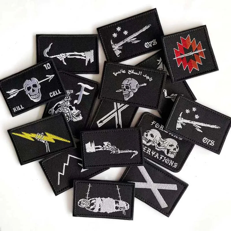 A collection of black embroidered pirate flags featuring skulls, swords, and hooks, with hook and loop backing.
