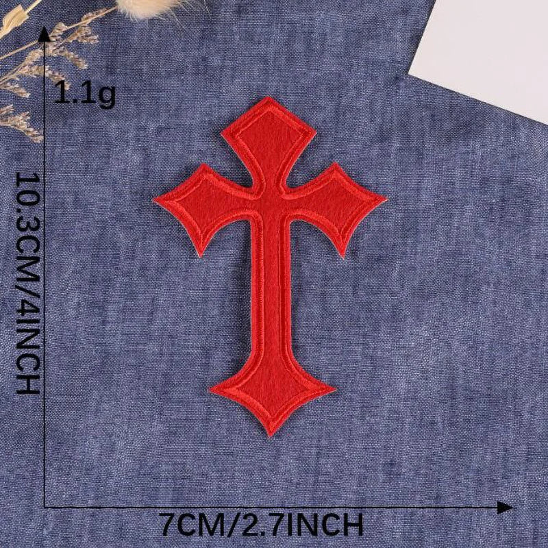 A single red cross embroidery patch on a dark blue fabric background.