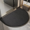 A black half-round non-slip PVC door mat placed on a tiled floor near a doorway.