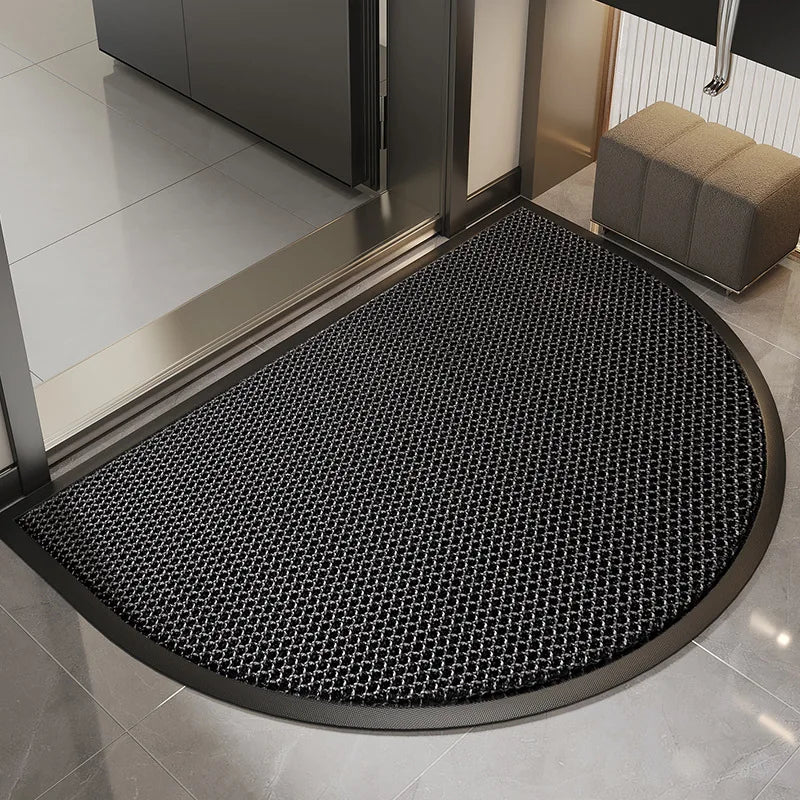 A black half-round non-slip PVC door mat placed on a tiled floor near a doorway.