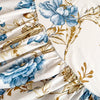 White bed sheet with a blue and gold floral print featuring large blossoms and leaves.