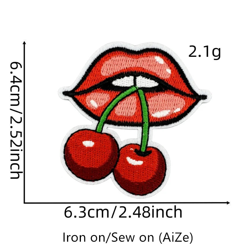 A close-up of a red cherry embroidered patch showing the size and detail for iron-on crafting.