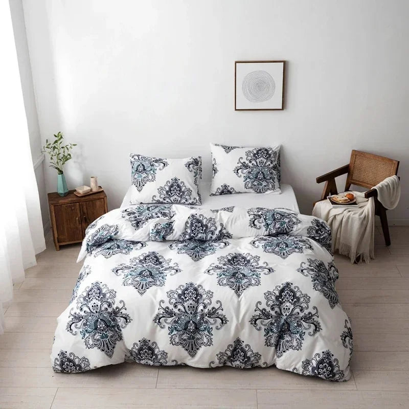 A white duvet cover set with a blue and gray floral geometric pattern displayed on a bed against a white wall.