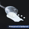 A clear glass pourer is dispensing white liquid onto a dark surface, demonstrating waterproof and spillproof properties.