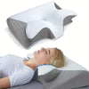 A white orthopedic memory foam neck pillow is shown next to a person sleeping on a pillow.