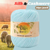 A ball of light blue silk and bamboo blend yarn is shown against a blurred outdoor background.