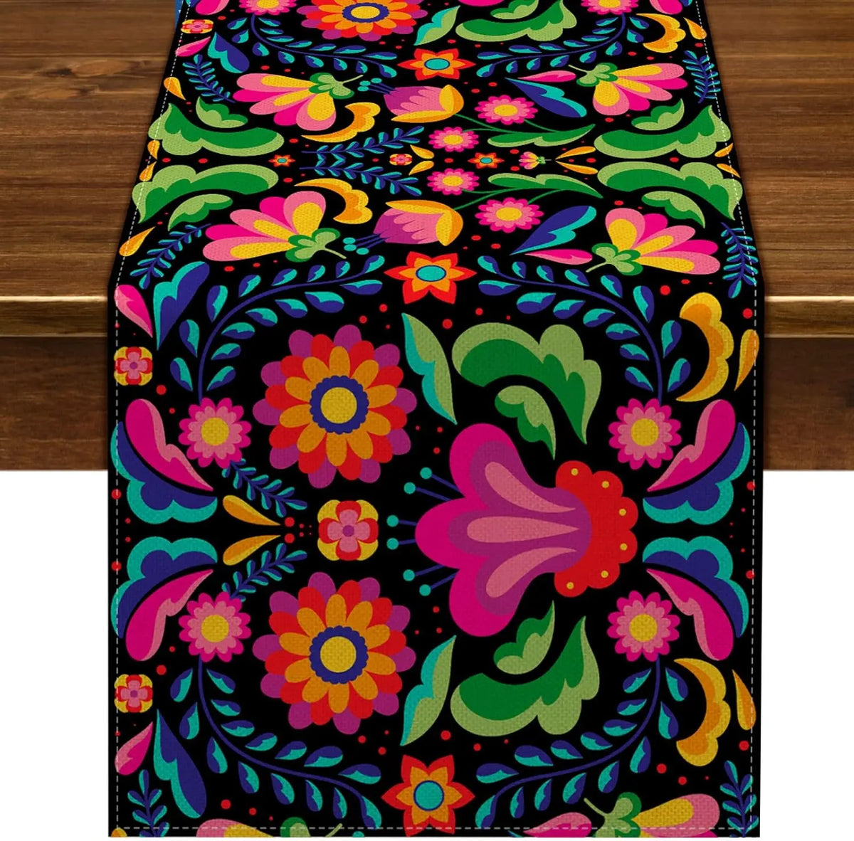 A vibrant floral pattern on a black linen table runner featuring pink, purple, orange, and green leaves.