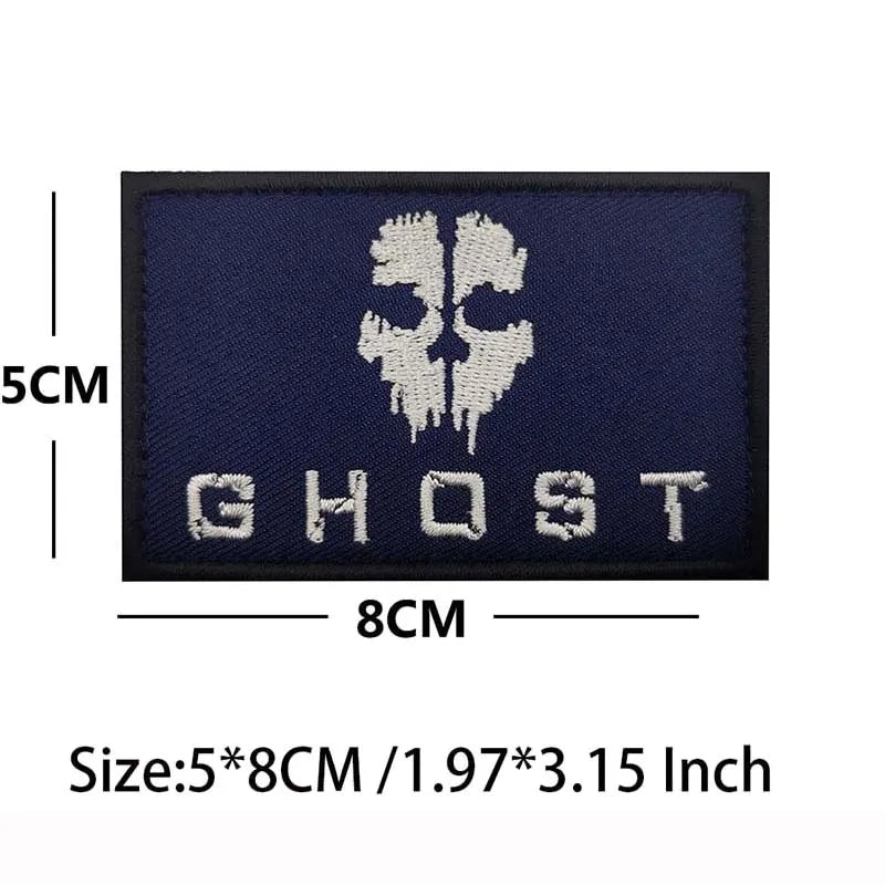 A dark blue embroidered patch featuring a white skull design and the word GHOST on a black fabric background