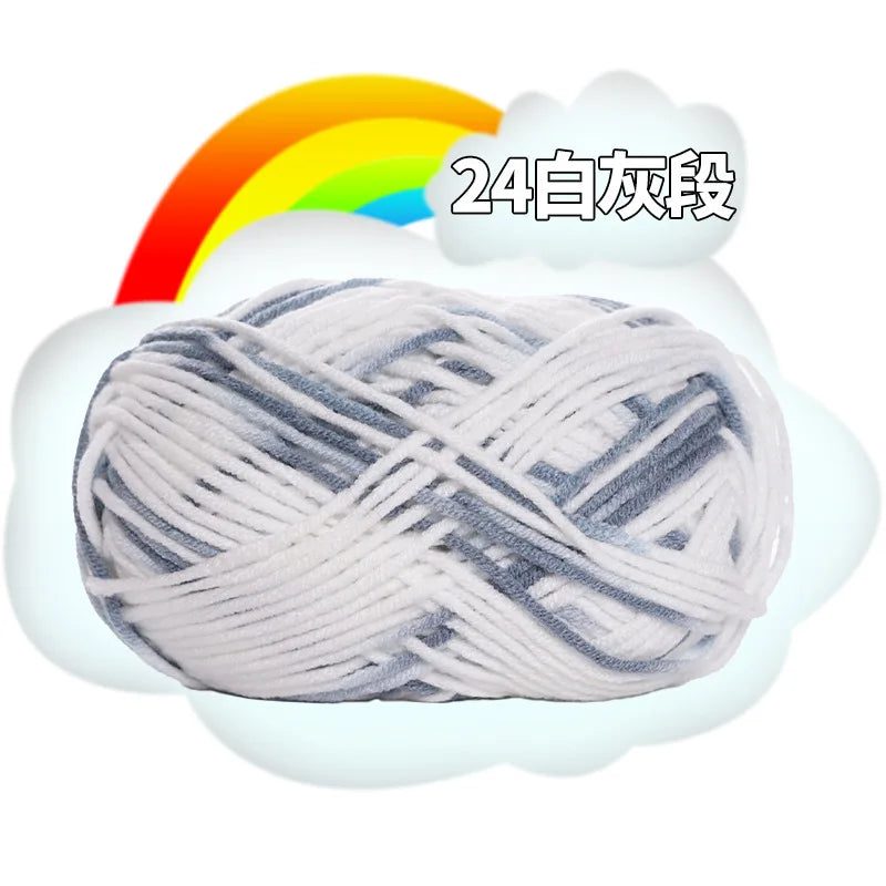 A ball of gray and white premium milk cotton yarn for knitting with a rainbow graphic.