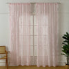 A pair of sheer pink floral lace curtains hanging in a white window frame.