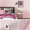 Pink self-adhesive 3D thermal insulation wallpaper with a linen texture applied to a bedroom wall.