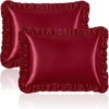 A set of two deep red satin pillowcases with ruffled edges and silky envelope closures.
