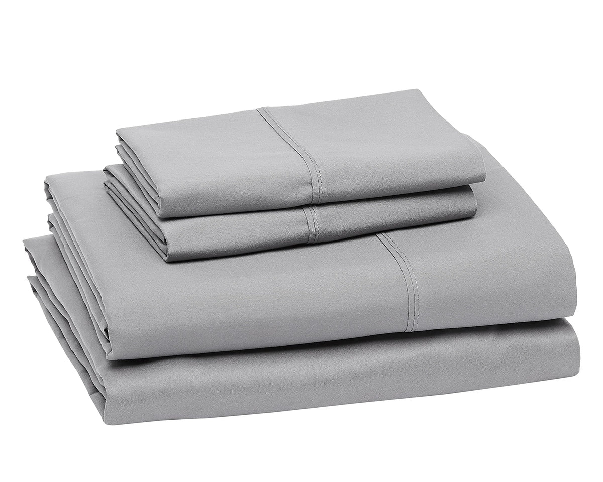 A stack of four gray microfiber flat fitted sheets.