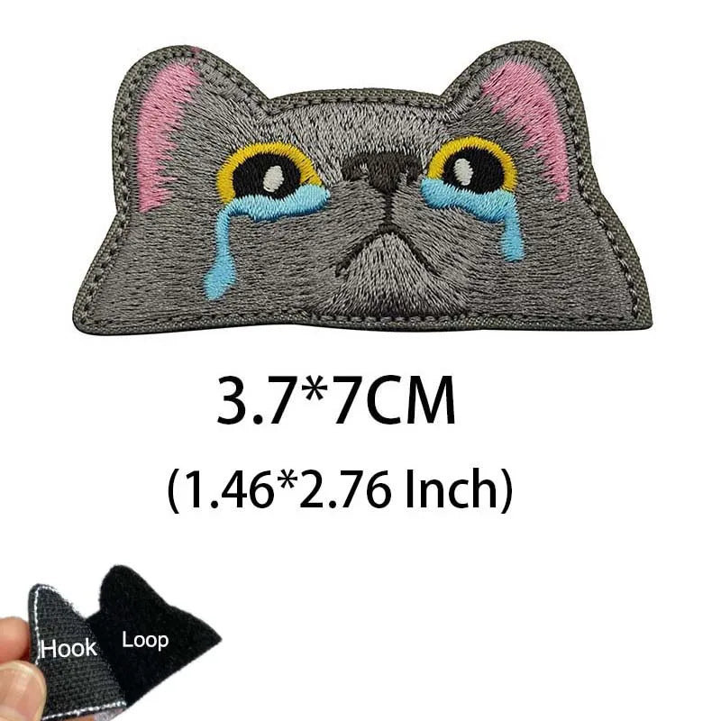 Embroidered tactical patch of a cat face with blue tear marks and pink ears