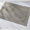 A rectangular linen placemat in a light gray color with decorative hand embroidery.