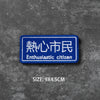 A blue embroidered badge with Japanese text Enthusiastic citizen on a gray textured background.