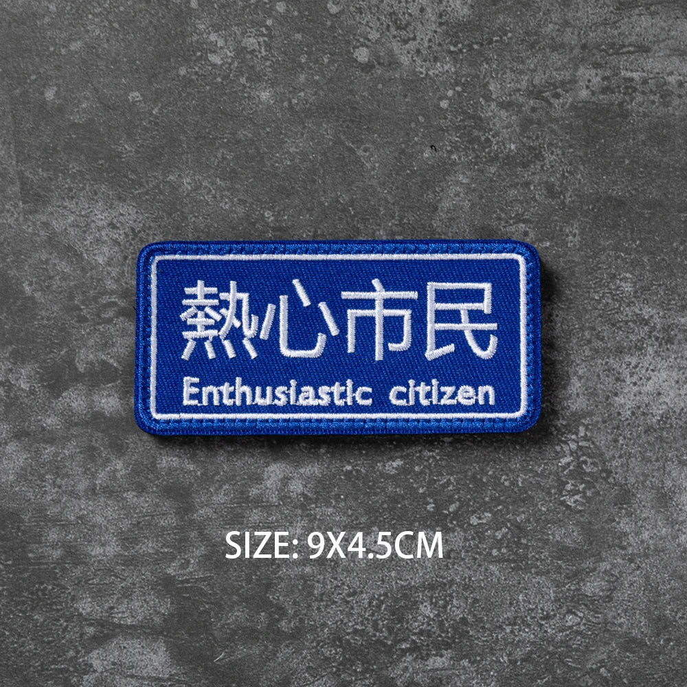 A blue embroidered badge with Japanese text Enthusiastic citizen on a gray textured background.