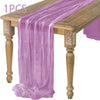 A purple semi-sheer gauze table runner draped over a wooden table.