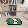 A green and yellow cartoon dollar tufted bathroom rug displayed in front of a wooden shelving unit.