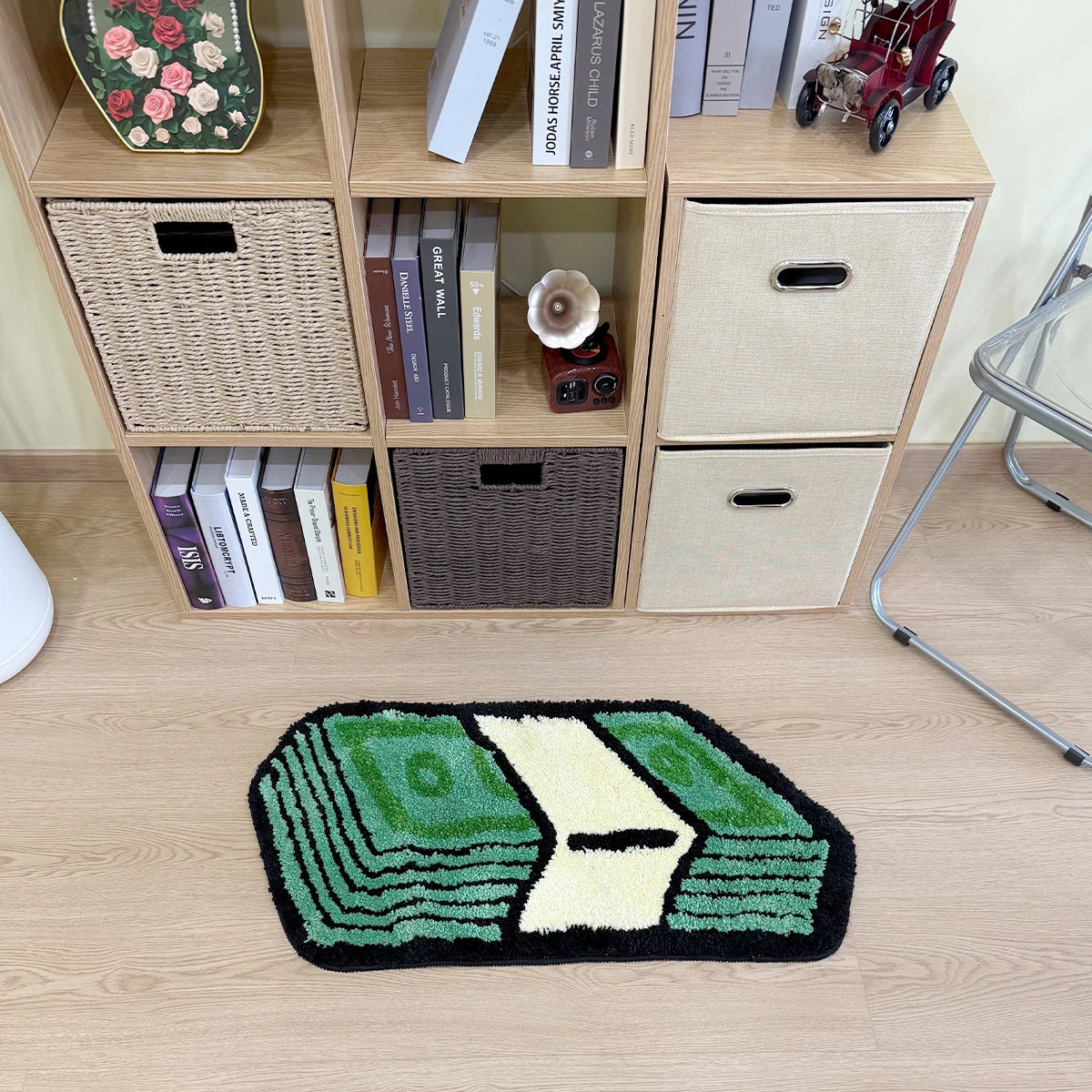 A green and yellow cartoon dollar tufted bathroom rug displayed in front of a wooden shelving unit.