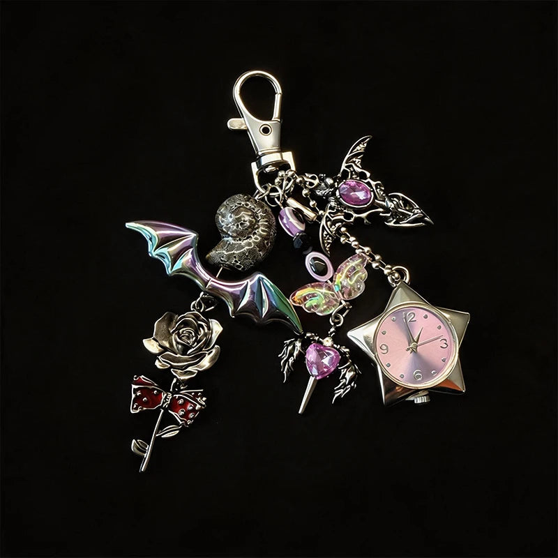 Silver and purple star-shaped pocket watch keychain featuring a rose, butterfly, and a textured sphere.