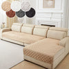 A beige anti-slip sofa cushion cover displayed on a light-colored sofa with decorative round cushions.