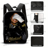 Black backpack featuring a person's face design, with details showing double zippers, side pockets, adjustment buckle, and br