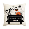 A white pillow featuring a spooky Halloween design with ghosts, bats, and an orange pumpkin on a black trunk.