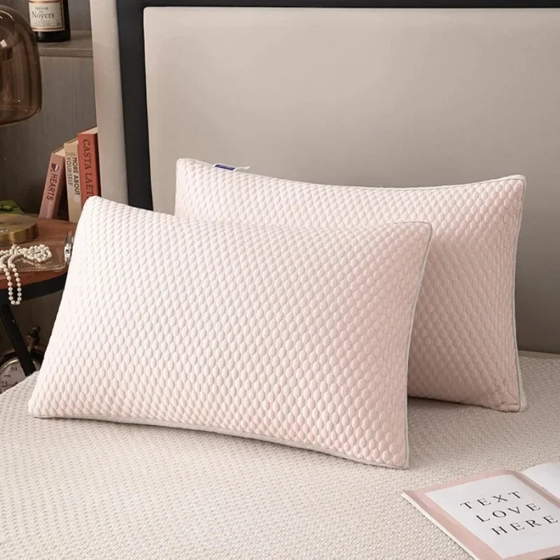 A pair of cream-colored quilted pillows resting on a light surface.