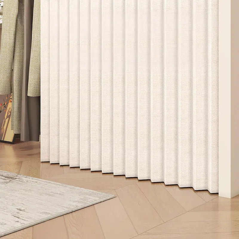 A beige pleated room divider curtain is shown vertically in a room with wooden flooring and a light rug.