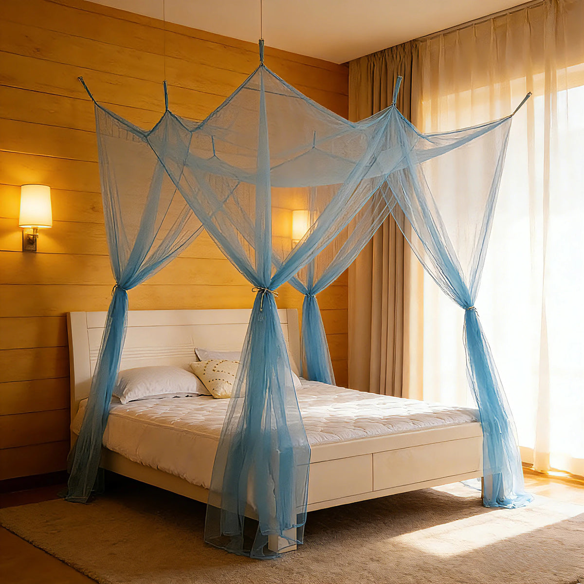 A square mosquito net bed canopy with light blue sheer fabric draped over a white bed in a warm-toned room.