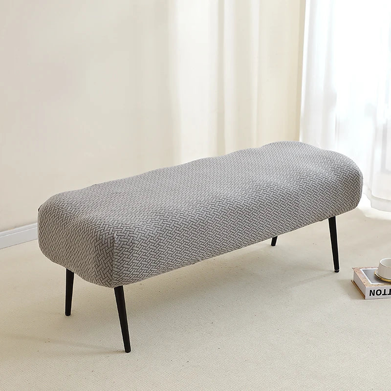 A gray elastic jacquard bench cover is shown on a light floor, ready for use as piano, dining, or entryway seating.