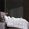 A white luxury goose down quilt duvet is displayed on a bed with dark gray and brown accents.